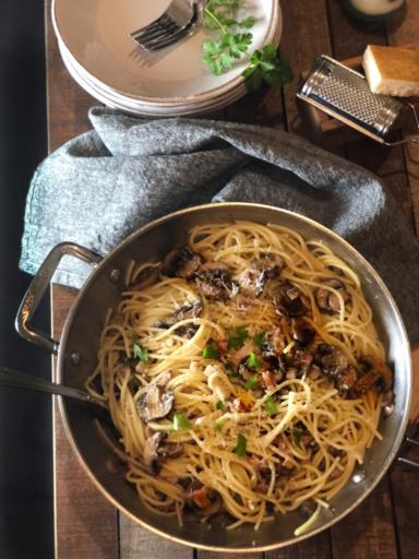 Špagety s houbami a pancettou na pánvi.