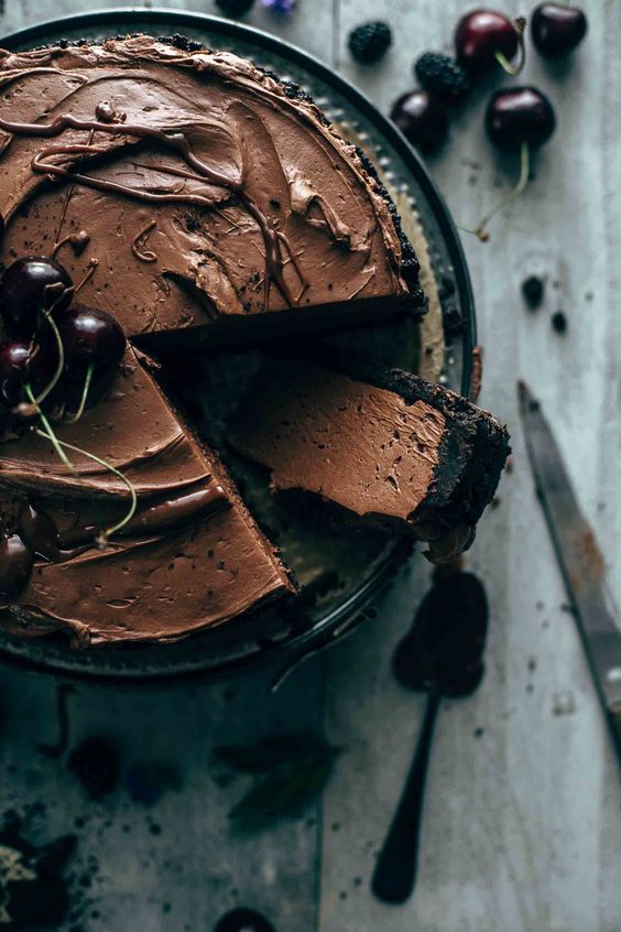 Celý koláč plný lahodné krémové čokoládové náplně ozdobený višněmi.
